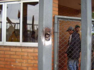 Outra imaxe, dun furado feito por unha bala no ferro de entrada da zona ocupada